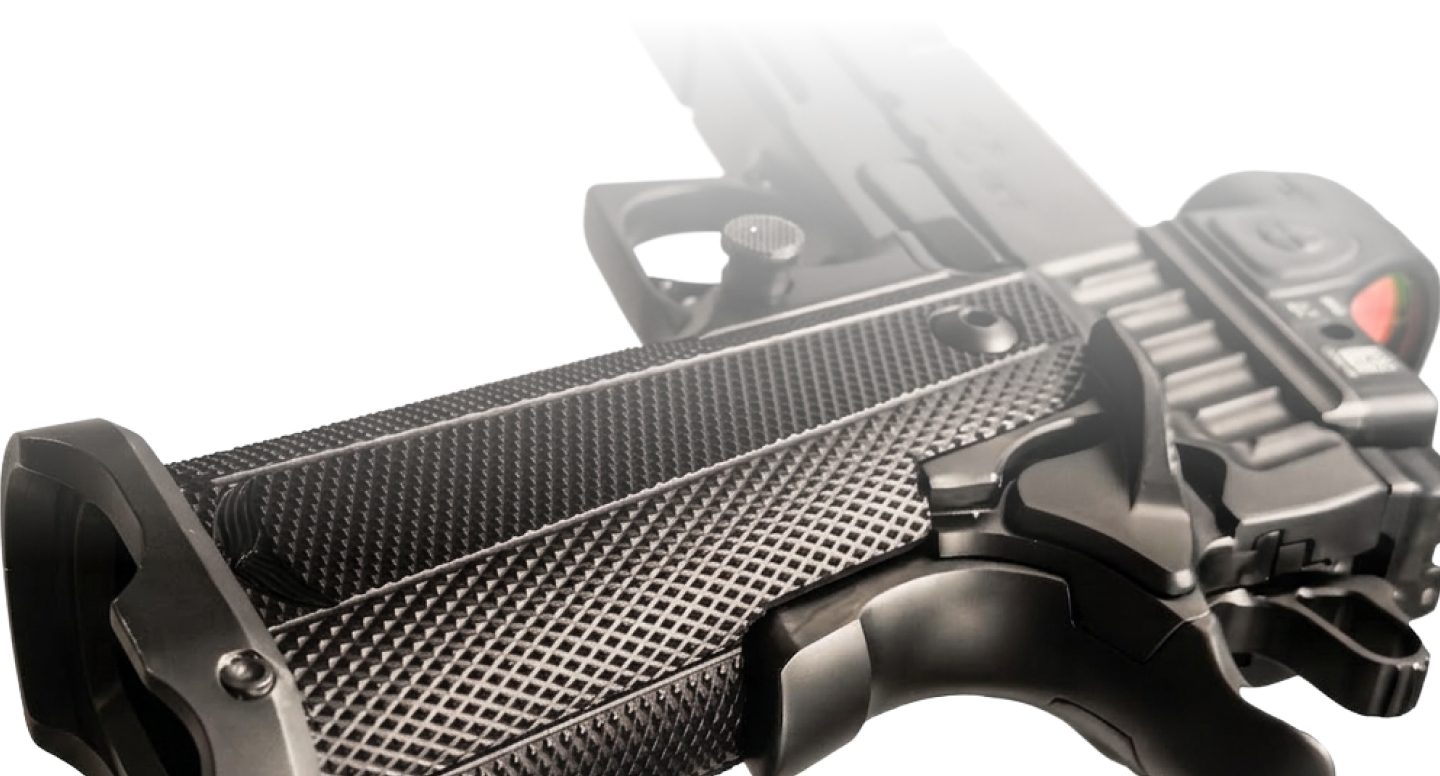Close-up view of a modern handgun grip and trigger detail on a neutral background