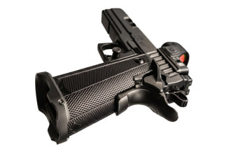 Close-up view of a modern handgun grip and trigger detail on a neutral background